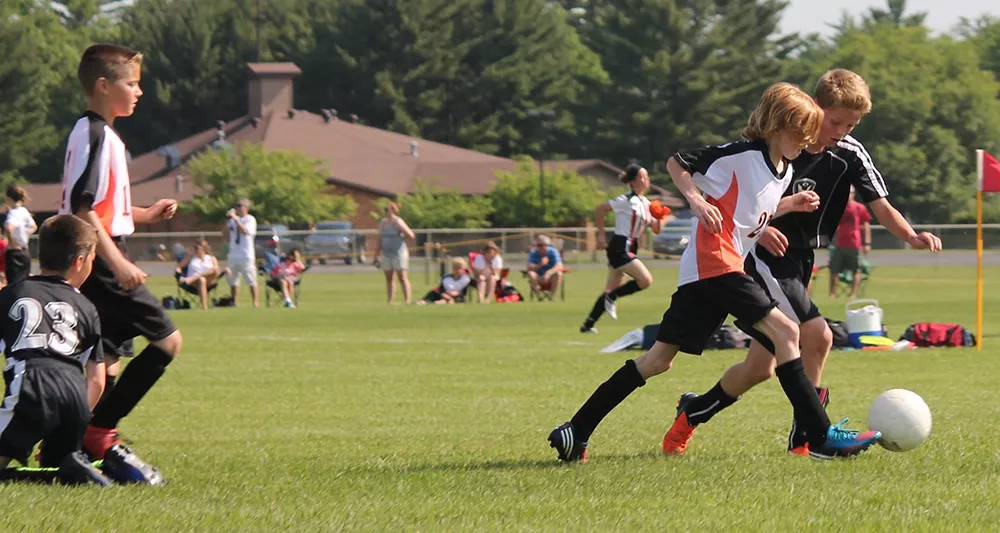 Kids playing soccer outdoors.
